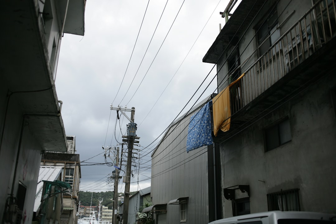 white car parked beside white building during daytime
