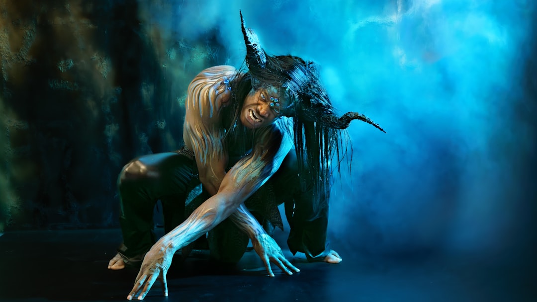 A creature with horns and dark hair dances dramatically.