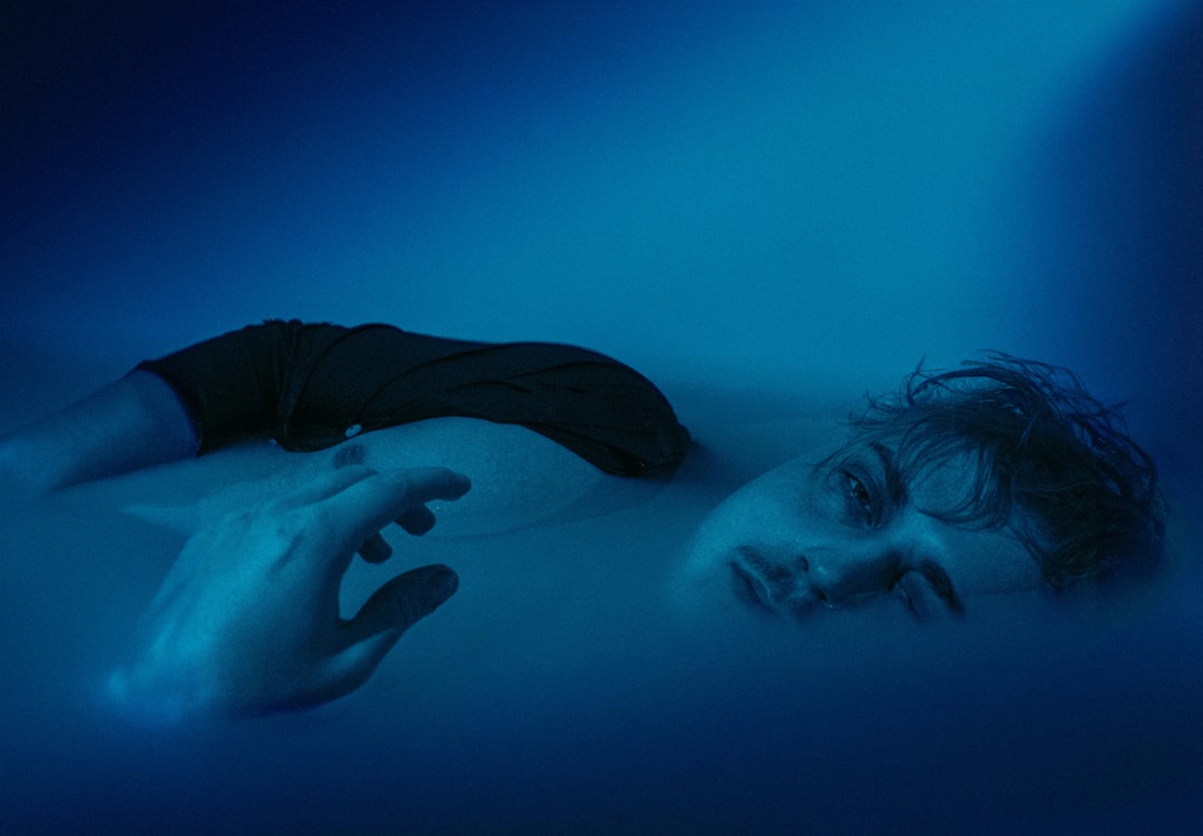 a man laying on the ground in the water