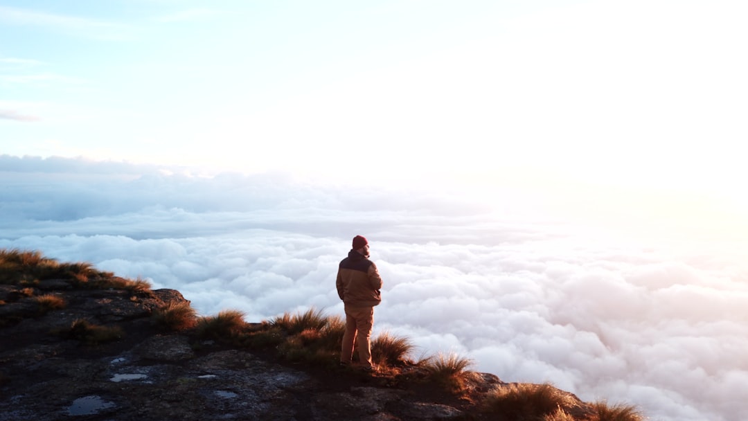 a person standing on top of a mountain above the clouds
